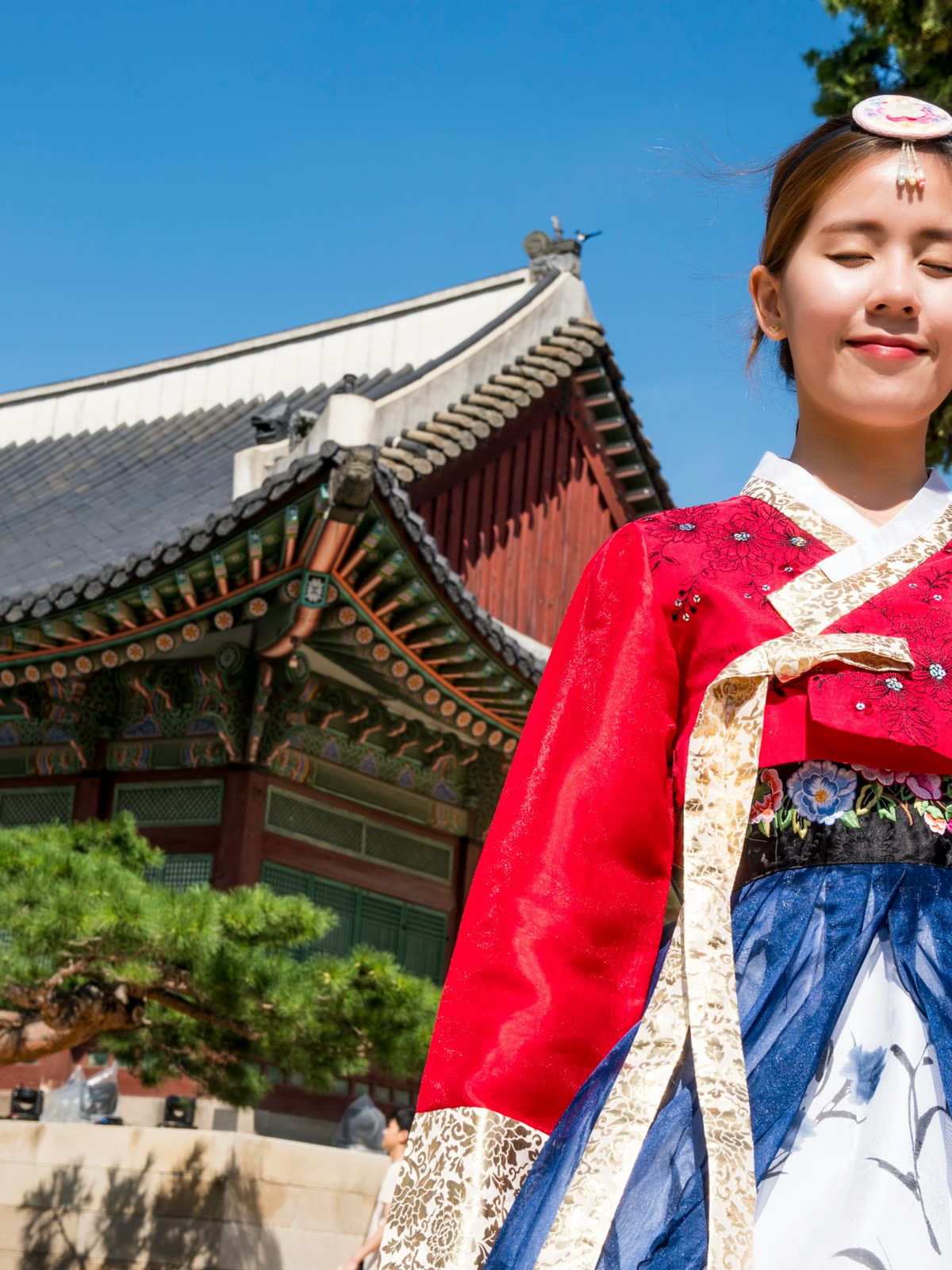 Jovem vestindo hanbok, o traje tradicional coreano, diante do Palácio Gyeongbokgung, em Seul