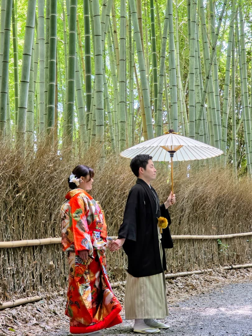 Casal em trajes tradicionais caminhando pelo bosque de bambu de Arashiyama